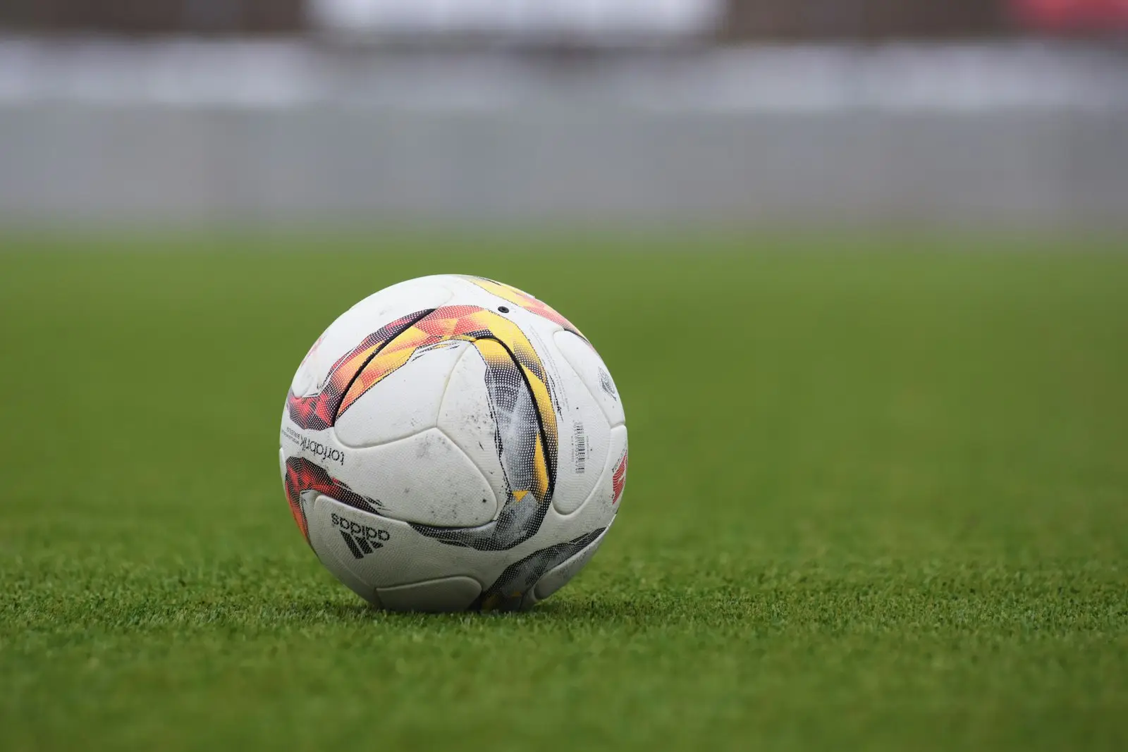 A football resting on a grass pitch